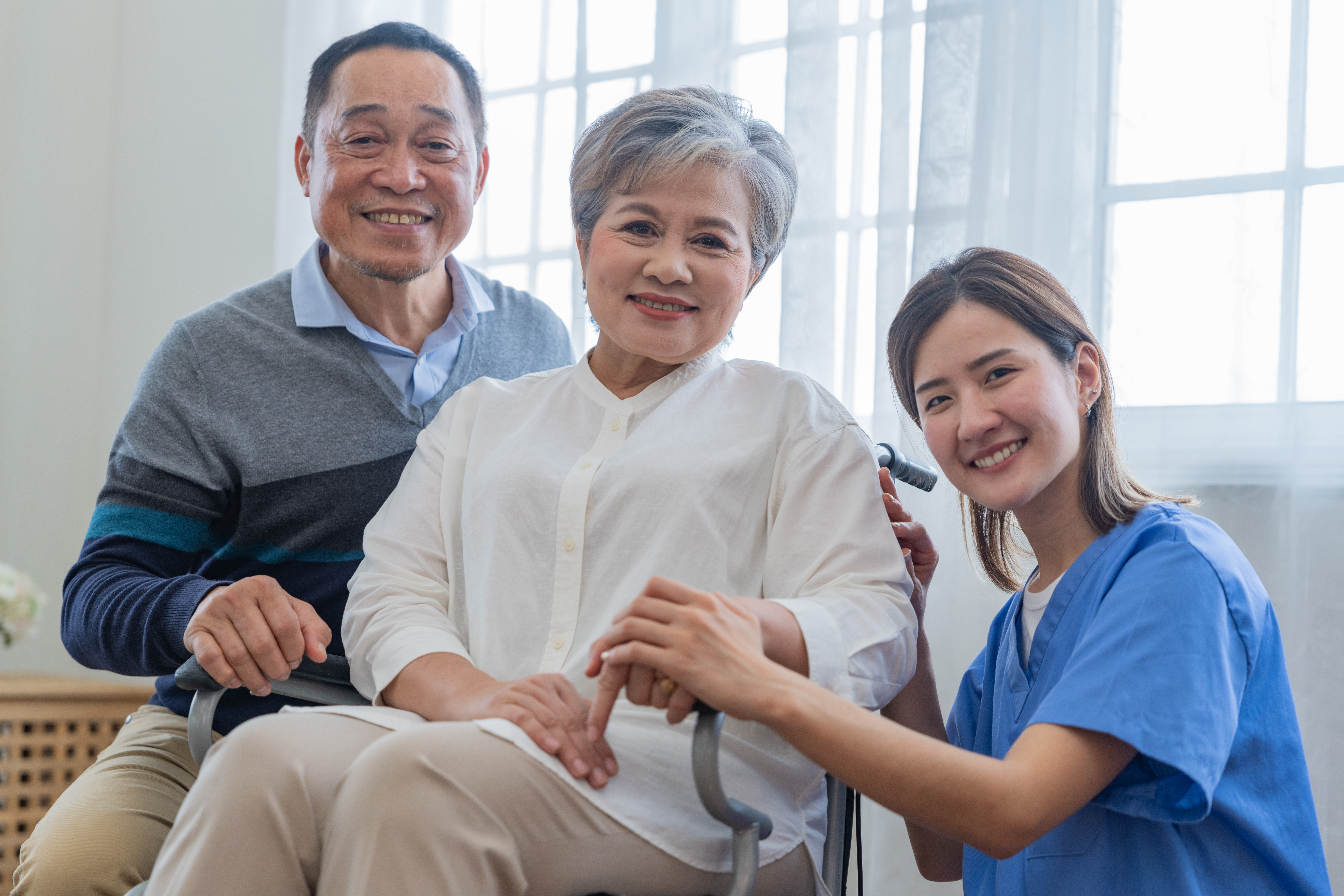 Asian young nurse support couple senior older man and woman in a wheelchair. elderly mature and a group of senior friends living in the hospital. socializing of retired people.